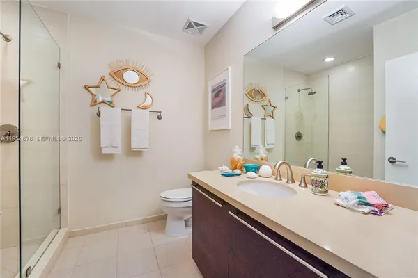a bathroom with a sink and mirror with toilet
