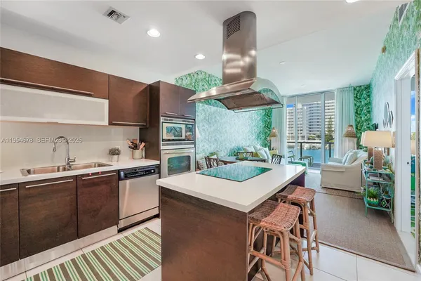 a kitchen with a sink a stove and chairs