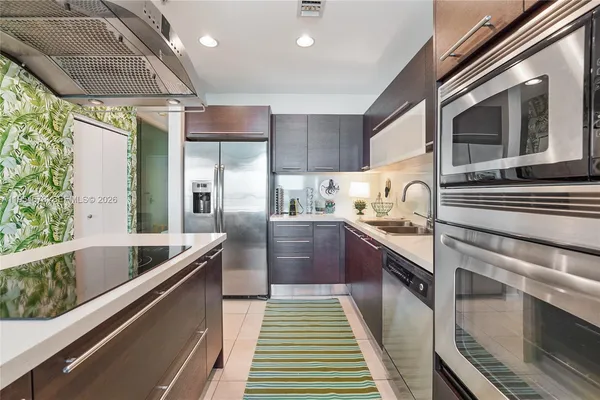 a kitchen with stainless steel appliances kitchen island granite countertop a stove and a sink