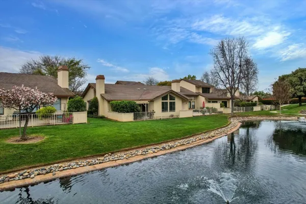 a view of a house with a yard and a fountain