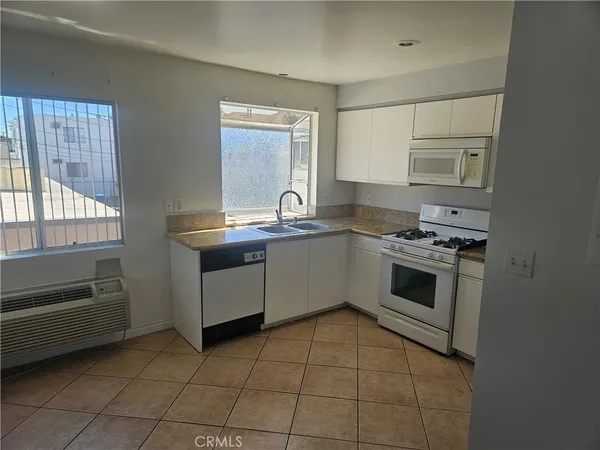 a kitchen with a stove sink and cabinets
