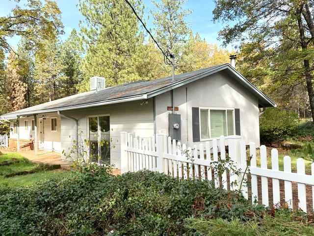 a kitchen with granite countertop a sink a counter space appliances and cabinets
