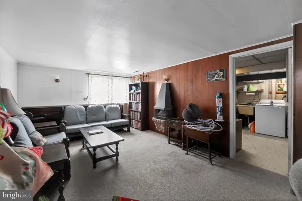 a living room with furniture a flat screen tv and gym equipment
