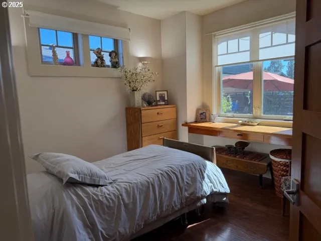 a bedroom with a bed and a table next to a window