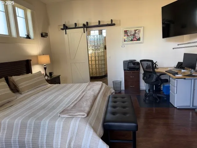 a bedroom with a bed window and a flat screen tv