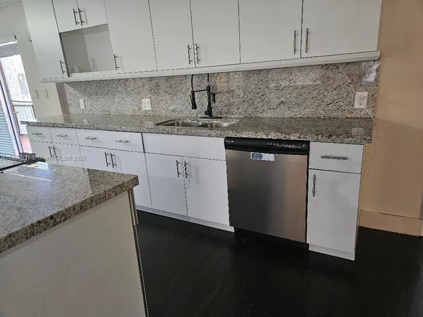 a kitchen with stainless steel appliances granite countertop a sink stove and cabinets