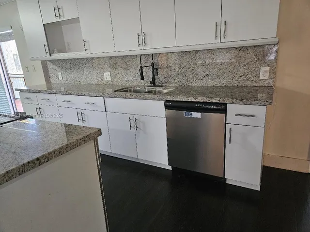 a kitchen with stainless steel appliances granite countertop a sink stove and cabinets