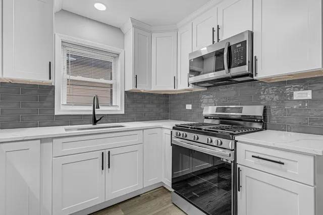 a kitchen with white cabinets and stainless steel appliances