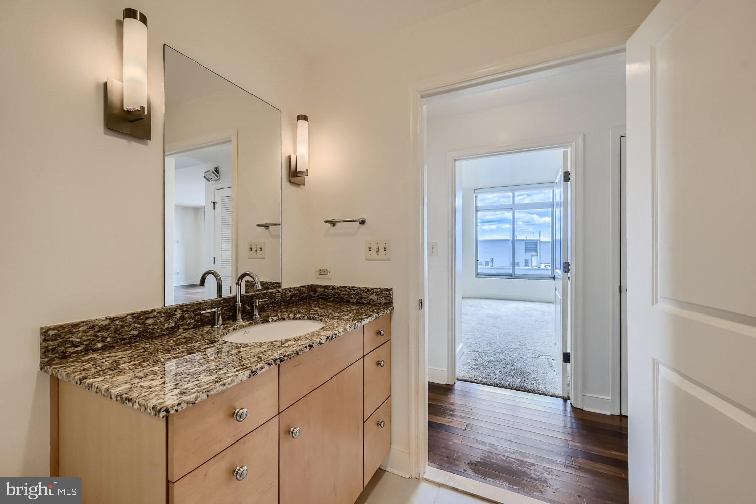 675 President Street, Unit 1709 Baltimore, MD 21202 - Photo 12 of 33 a bathroom with a granite countertop sink and a mirror
