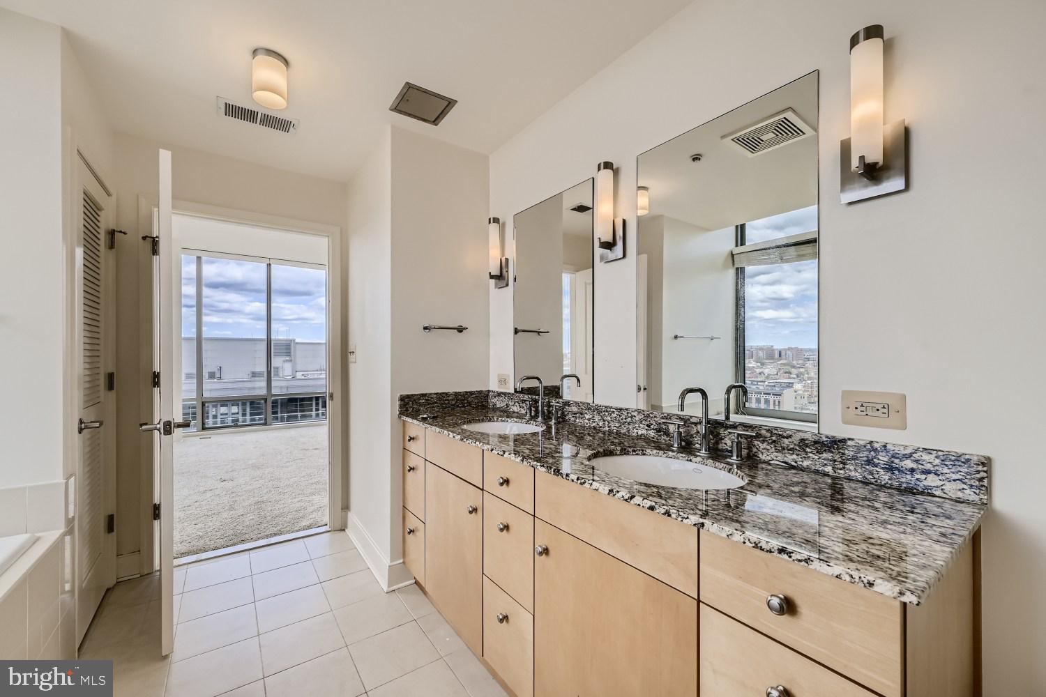 675 President Street, Unit 1709 Baltimore, MD 21202 - Photo 6 of 33 a bathroom with a granite countertop sink and a mirror