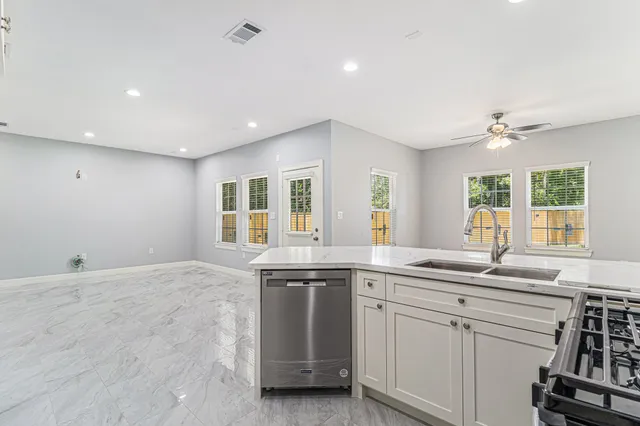 a kitchen with granite countertop a sink and white cabinets