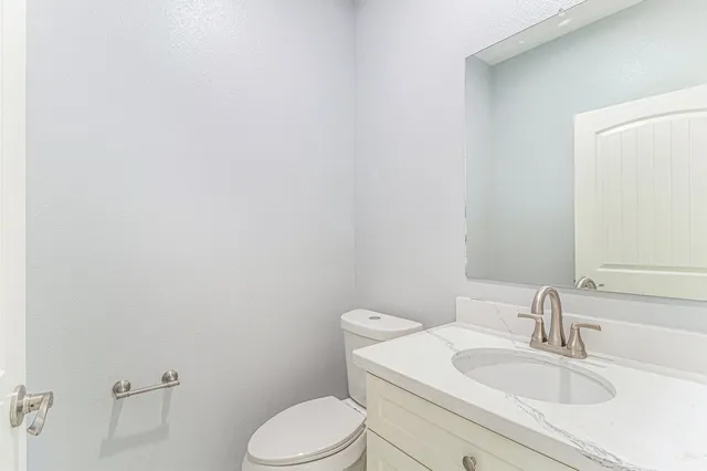 a bathroom with a toilet a sink and mirror