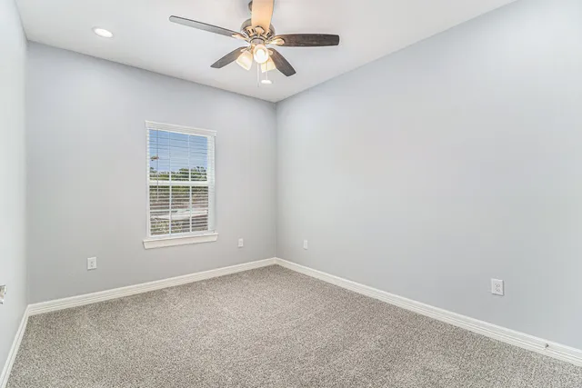 an empty room with chandelier fan and closet