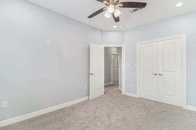 a bathroom with a granite countertop toilet a sink a mirror and a window