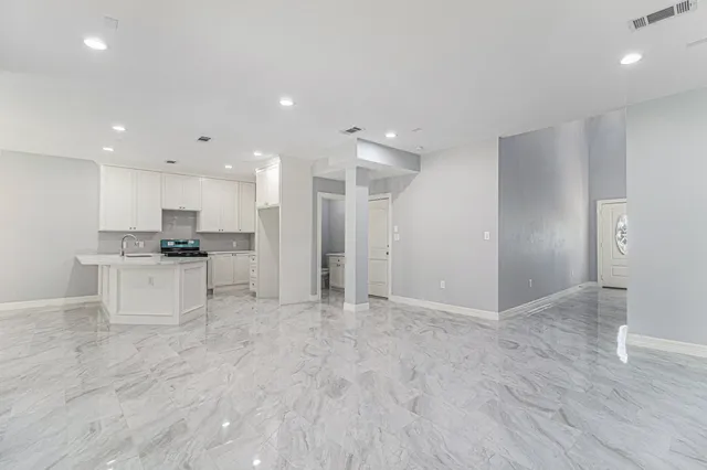 a view of kitchen with granite countertop a stove top oven a sink and a refrigerator