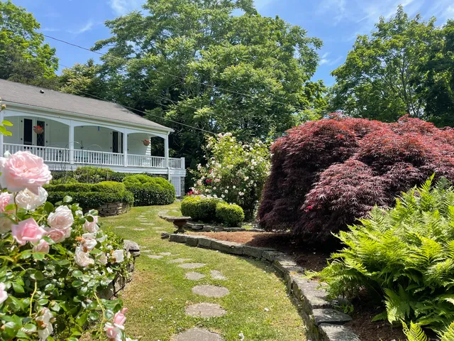 a view of a house with a yard and sitting area