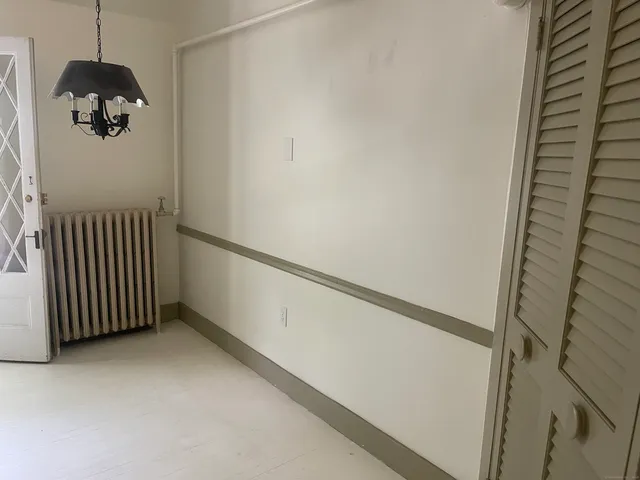 a view of a hallway with a white door and a window