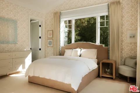 a bedroom with a bed and a couch next to a window