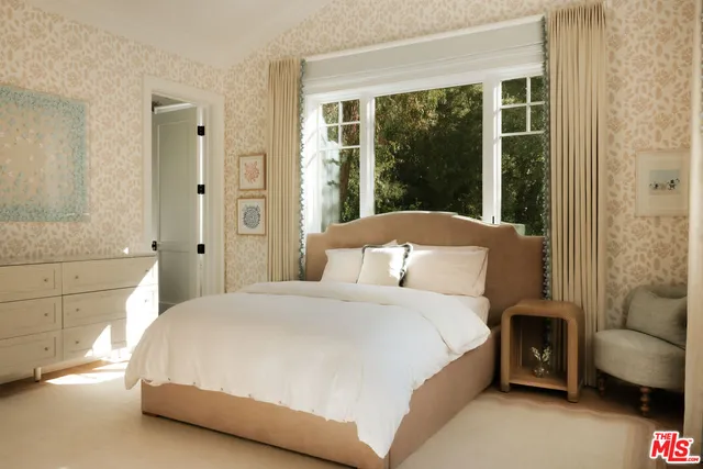 a bedroom with a bed and a couch next to a window