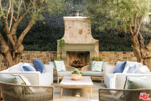a view of a patio with couches fire pit and a table and chairs