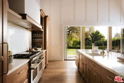 a kitchen with stainless steel appliances a sink stove and a window