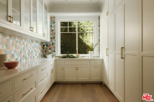 a bathroom with a sink and mirror with bathtub