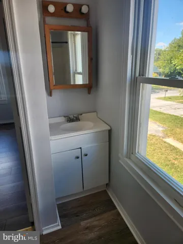 a view of a small space with wooden floor and a window