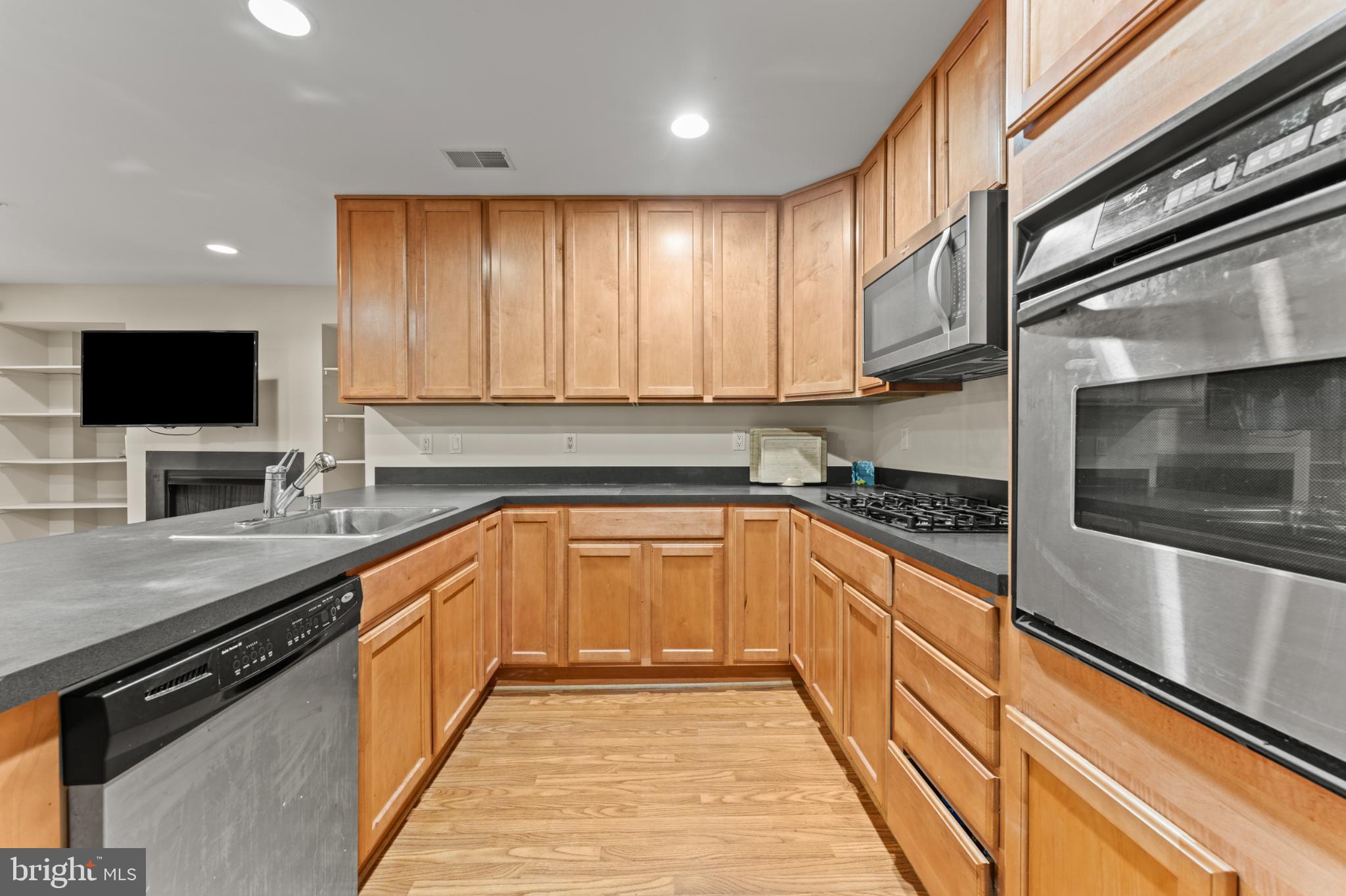 9510 Coyle Road, Unit 201 Owings Mills, MD 21117 - Photo 10 of 34 Modern kitchen with warm wood cabinetry