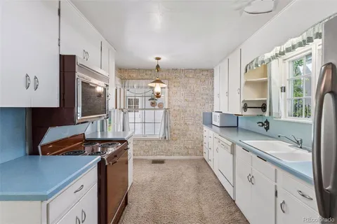 a kitchen with granite countertop a sink stove and cabinets