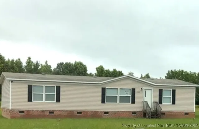 a front view of a house with a garden and yard