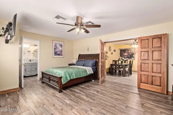 a bedroom with a bed a table and painting on the wall