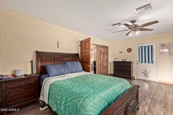 a bedroom with a bed and wooden floor