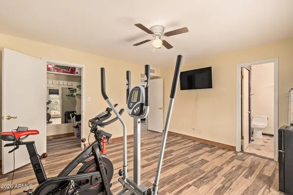 a view of a room with gym equipment and a flat screen tv