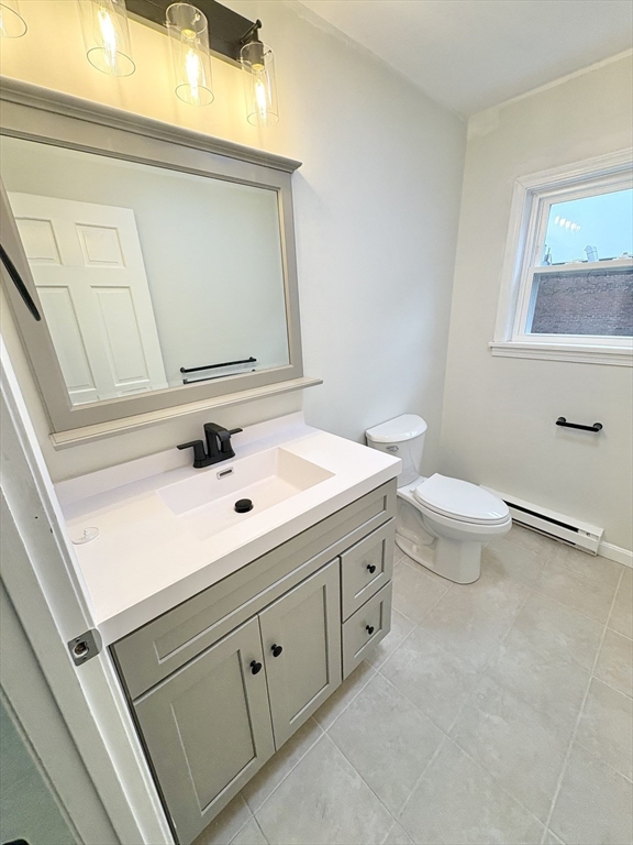 33 Home Street, Unit A Beverly, MA 01915 - Photo 3 of 12 a bathroom with a sink a toilet and mirror