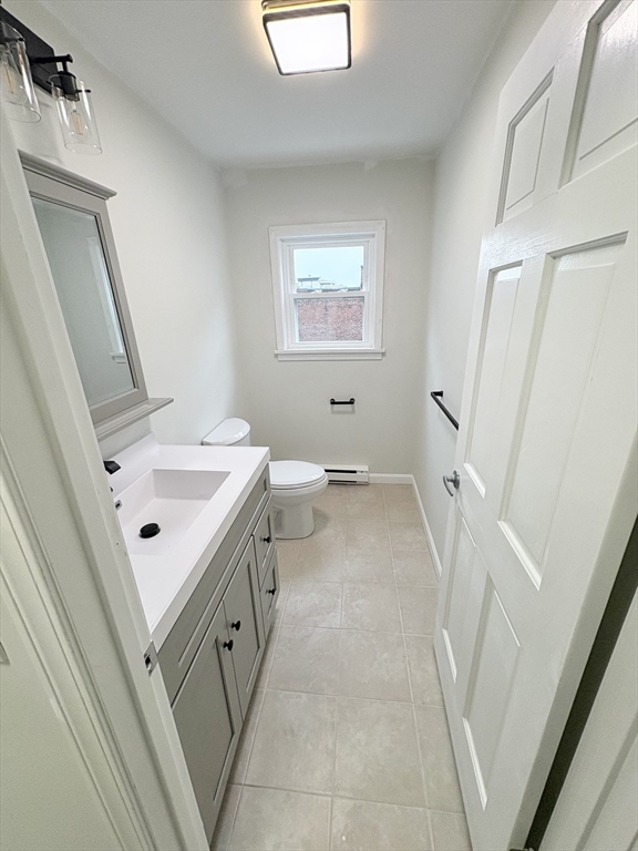 33 Home Street, Unit A Beverly, MA 01915 - Photo 4 of 12 a bathroom with a sink a mirror and a toilet