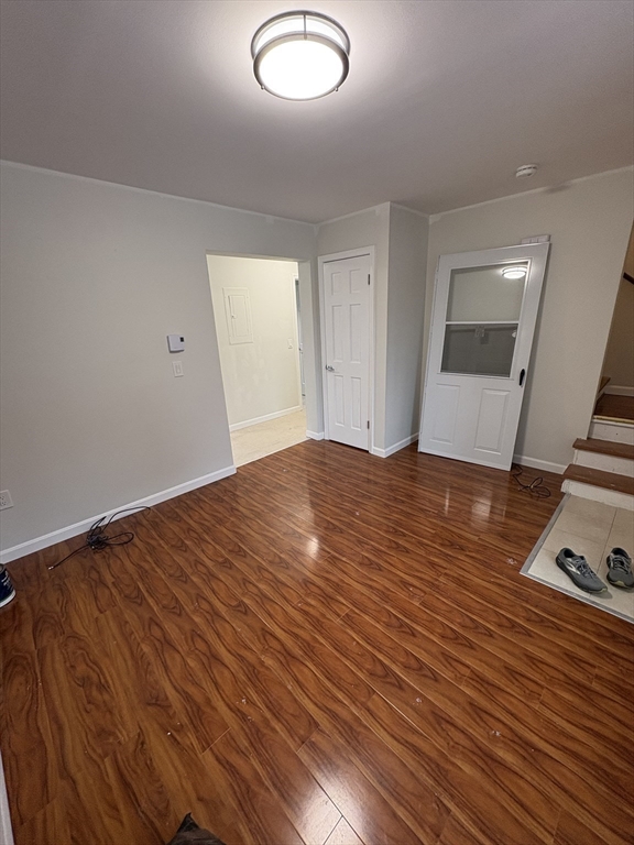 33 Home Street, Unit A Beverly, MA 01915 - Photo 6 of 12 an empty room with wooden floor and windows