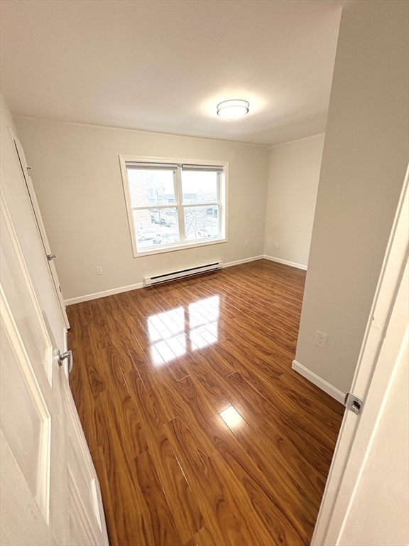 33 Home Street, Unit A Beverly, MA 01915 - Photo 8 of 12 a view of an empty room with wooden floor and a window