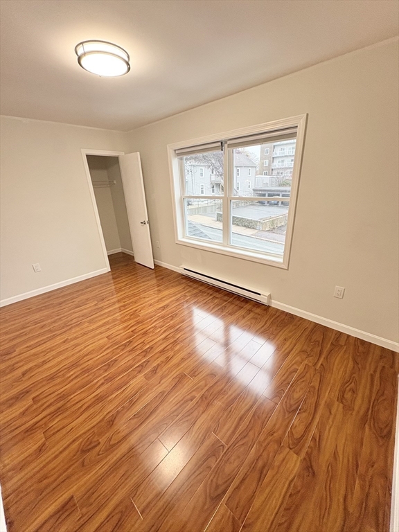 33 Home Street, Unit A Beverly, MA 01915 - Photo 10 of 12 a view of an empty room with wooden floor and a window