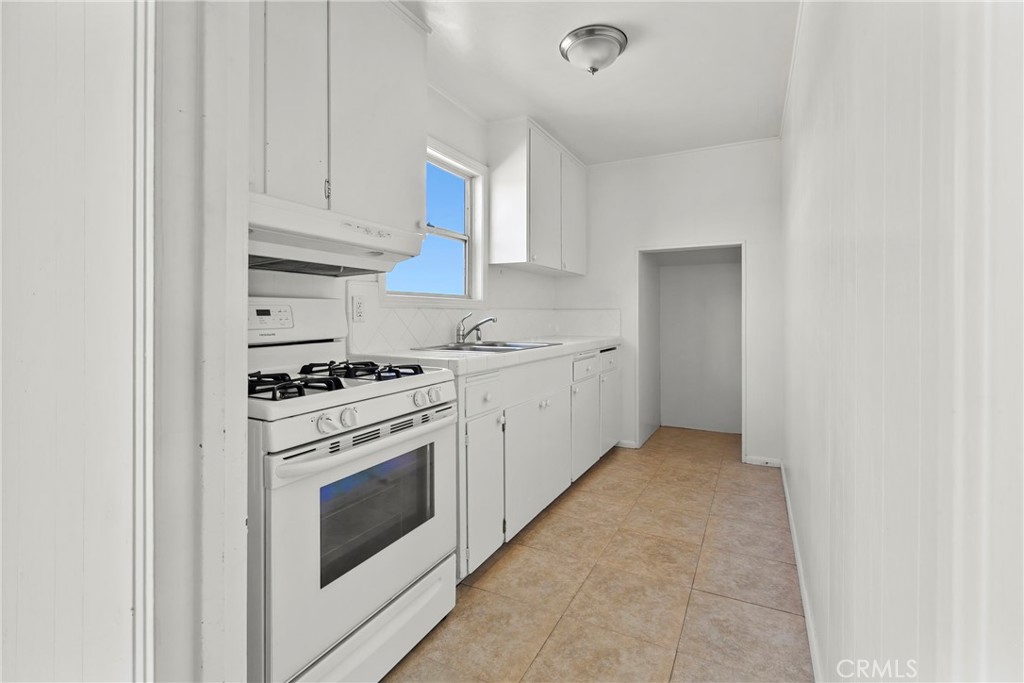 117 West El Campo Road Arroyo Grande, CA 93420 - Photo 17 of 43 a kitchen with a stove top oven and white cabinets