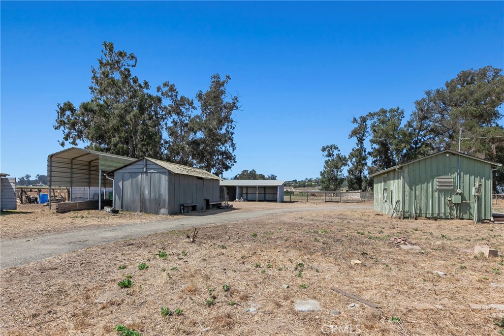 117 West El Campo Road Arroyo Grande, CA 93420 - Photo 31 of 43 a front view of a house with a dirt yard and a large tree