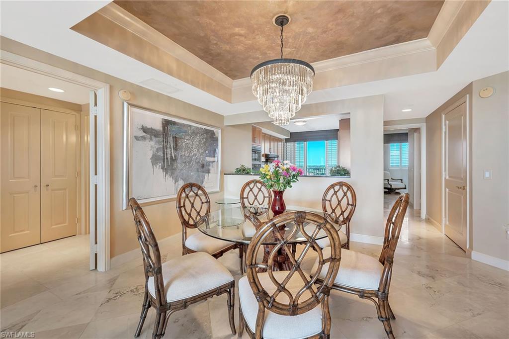 6597 Nicholas Boulevard, Unit 1002 Naples, FL 34108 - Photo 14 of 41 a view of a dining room furniture and chandelier