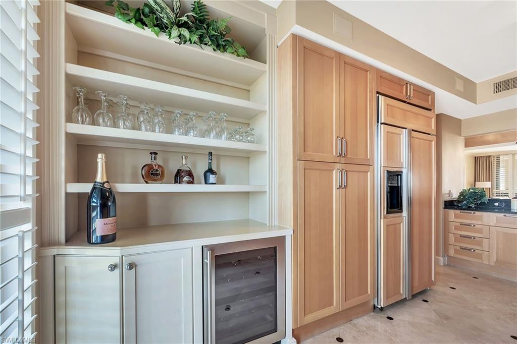 6597 Nicholas Boulevard, Unit 1002 Naples, FL 34108 - Photo 17 of 41 a kitchen with a refrigerator and cabinets