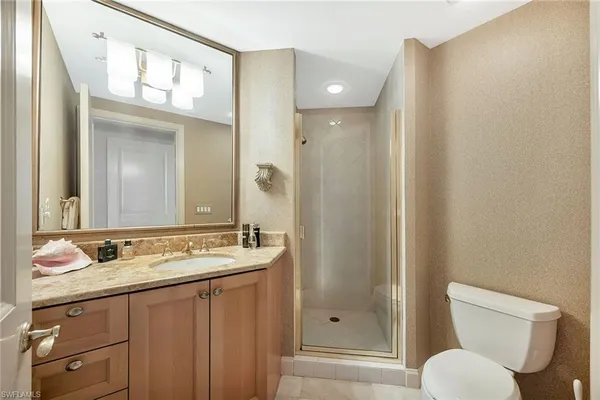 a bathroom with a granite countertop sink toilet and shower