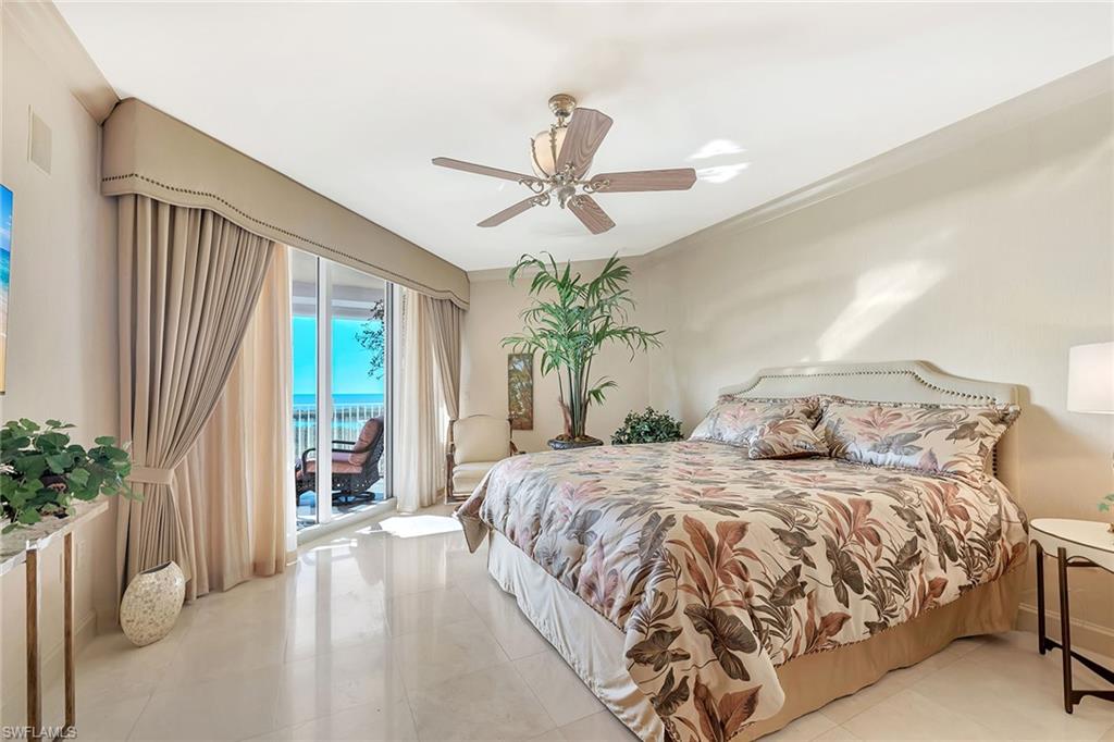 6597 Nicholas Boulevard, Unit 1002 Naples, FL 34108 - Photo 22 of 41 a bedroom with a large bed and a chandelier fan