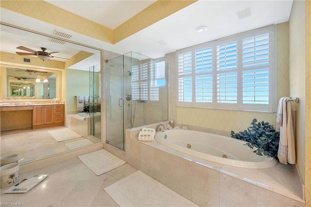 6597 Nicholas Boulevard, Unit 1002 Naples, FL 34108 - Photo 24 of 41 a spacious bathroom with a tub shower and a mirror