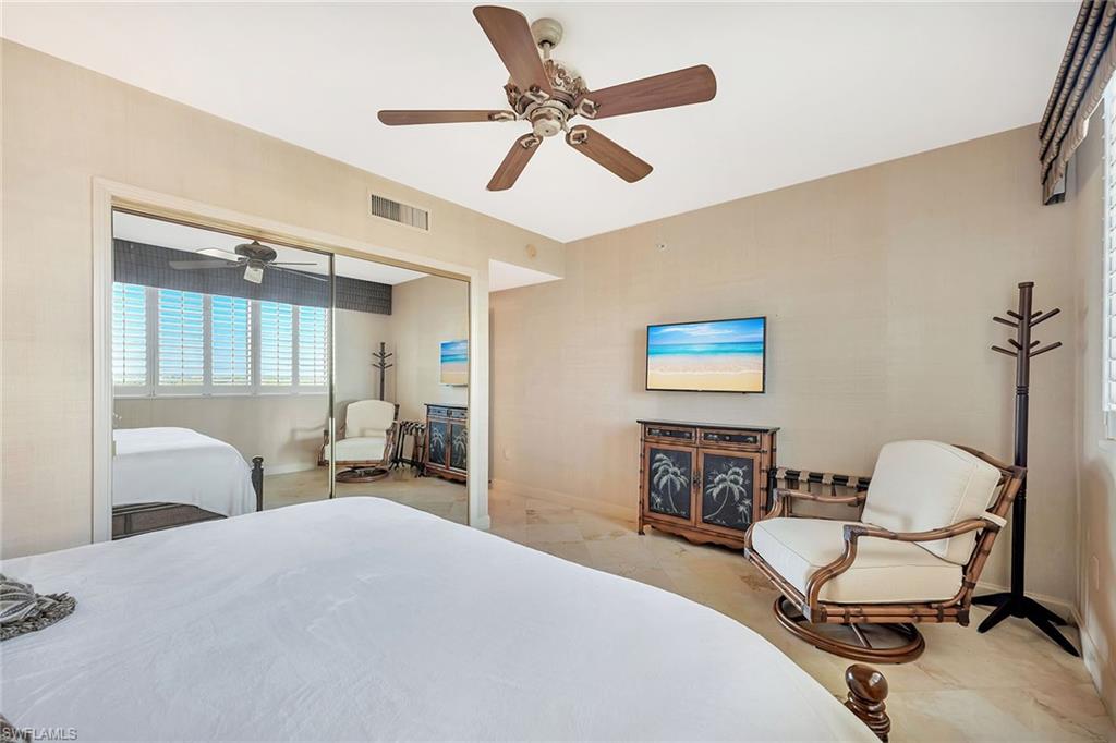 6597 Nicholas Boulevard, Unit 1002 Naples, FL 34108 - Photo 26 of 41 a bedroom with a bed and a chair