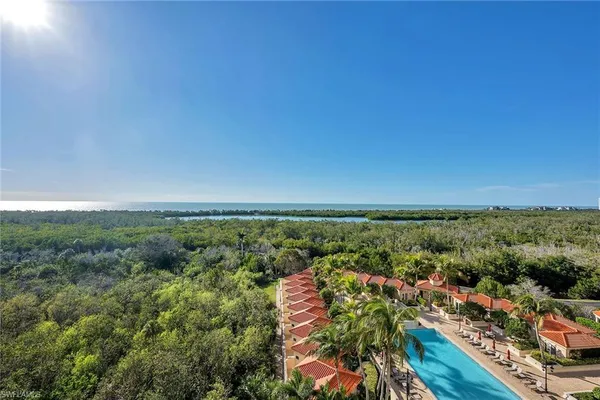an aerial view of residential houses with outdoor space and trees