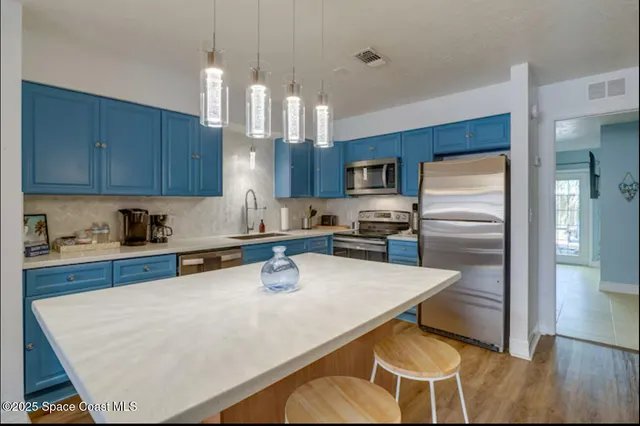 a kitchen with stainless steel appliances a refrigerator and a stove top oven