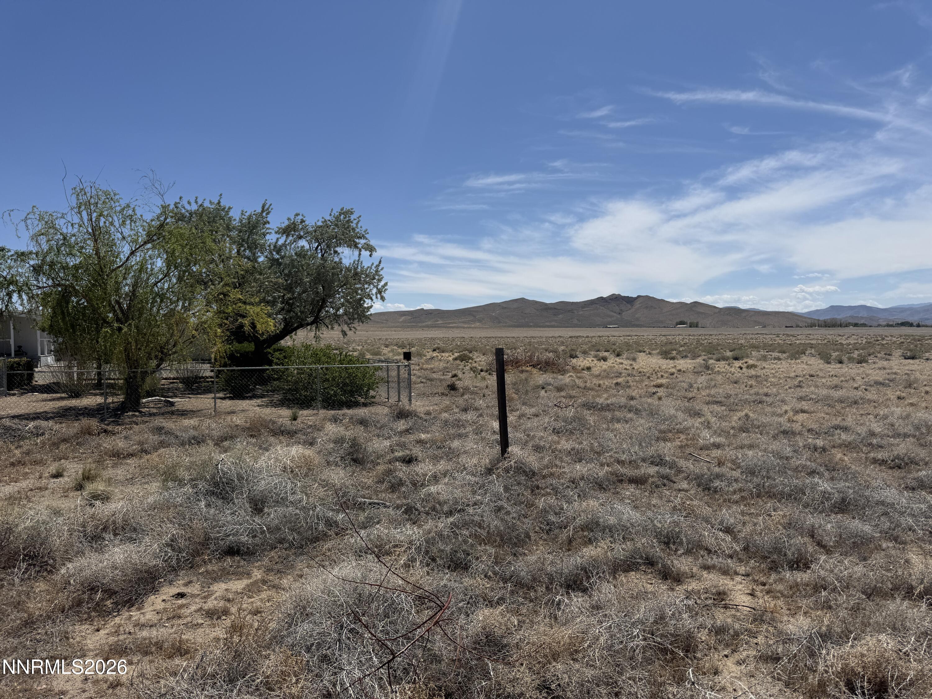 0 Rock Road Yerington, NV 89447 - Photo 3 of 12 a view of a dry yard with trees in the background