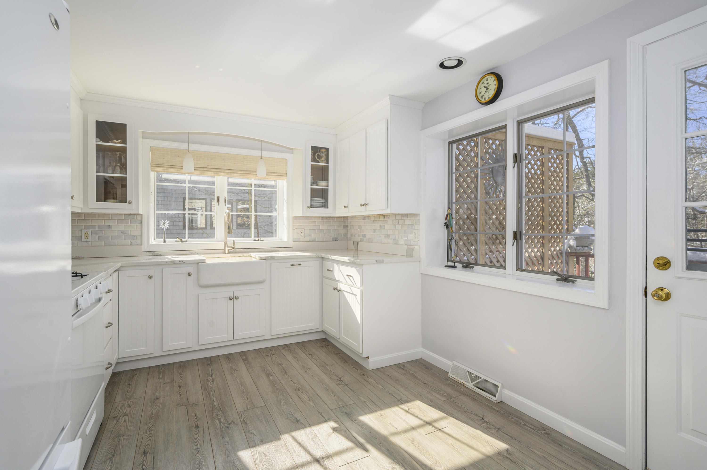 8 Ruth Lane Harwich, MA 02645 - Photo 7 of 20 a kitchen with white cabinets and wooden floors